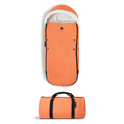 A stroller with a orange colored padded footmuff, cream fleece lining, and a black frame, shown from the front on a white background.