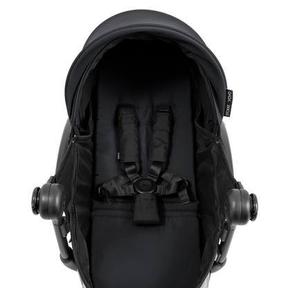 A yoyo stroller bassinet attachment set in black, shown mounted on a stroller frame against a solid white background.