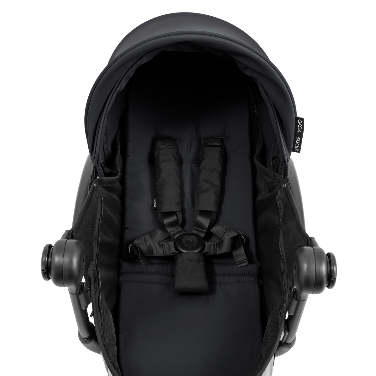A black stroller newborn travel system shown in black, with a stroller behind it to demonstrate compatibility, on a clean white background.