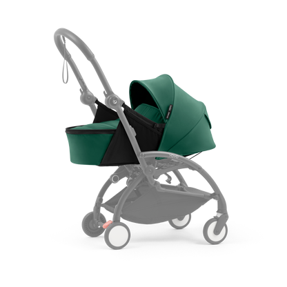 A yoyo stroller bassinet attachment set in dark green and black, shown mounted on a stroller frame against a solid white background.
