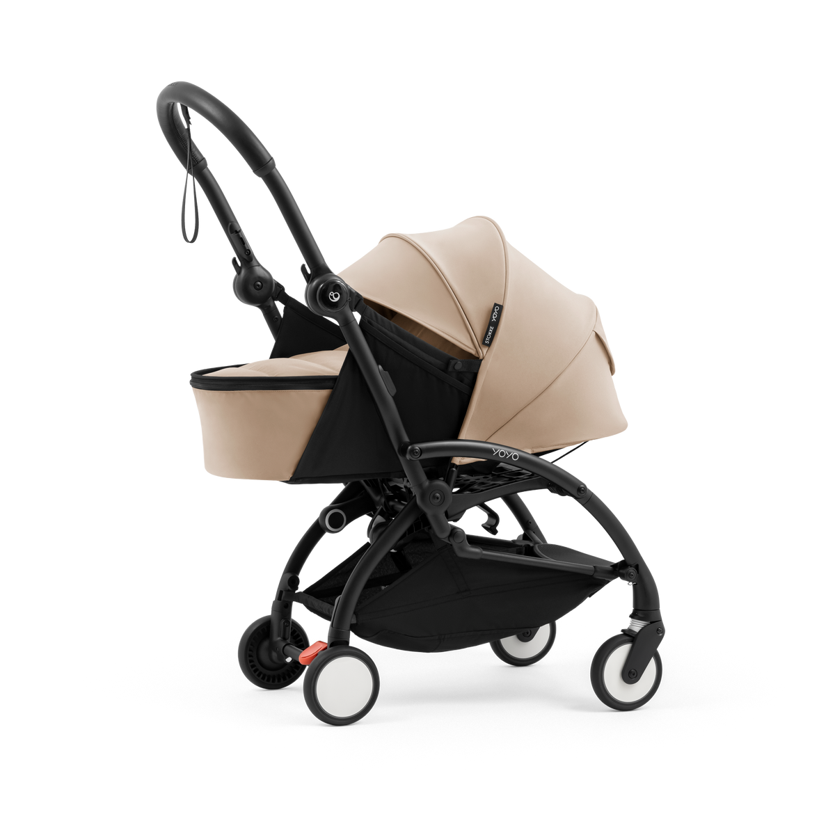 A black stroller newborn travel system shown in beige, with a stroller behind it to demonstrate compatibility, on a clean white background.
