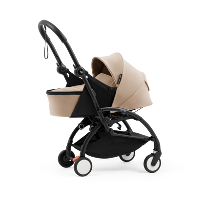 A yoyo stroller bassinet attachment set in beige and black, shown mounted on a stroller frame against a solid white background.