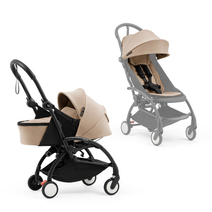 A black stroller newborn travel system shown in beige, with a stroller behind it to demonstrate compatibility, on a clean white background.
