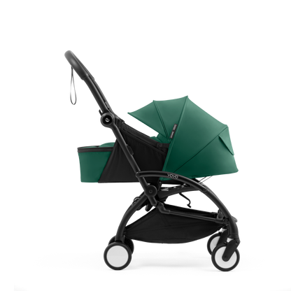 A yoyo stroller bassinet attachment set in dark green and black, shown mounted on a stroller frame against a solid white background.