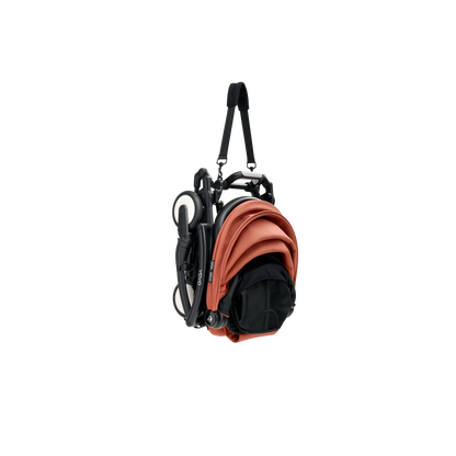 A compact yoyo 5 stroller with a rust-orange canopy and seat lining, a black frame, and black wheels, shown on a plain white background.