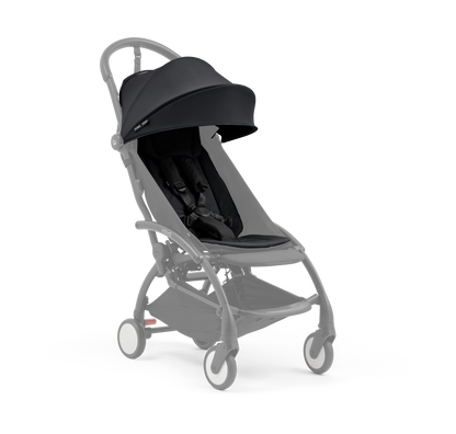 A compact baby stroller with a black canopy and black padded seat, with a blacked out chassis, shown on a plain white background.