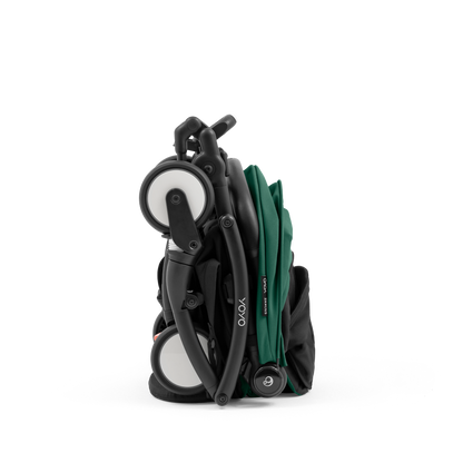 A compact yoyo 5 stroller with a green canopy and seat lining, a black frame, and black wheels, shown on a plain white background.