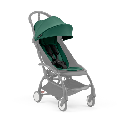 A compact baby stroller with a dark green canopy and dark green padded seat, with a blacked out chassis, shown on a plain white background.