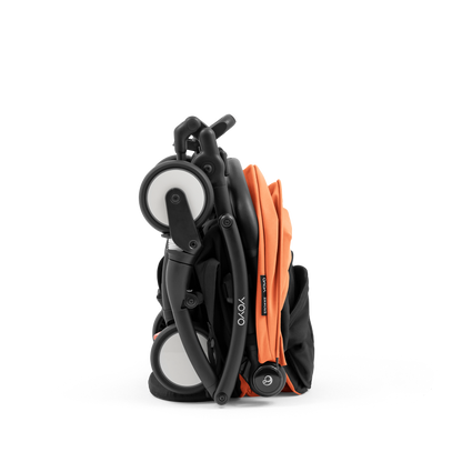 A compact yoyo 5 stroller with a peach orange canopy and seat lining, a black frame, and black wheels, shown on a plain white background.