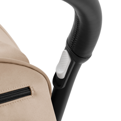 A compact yoyo 5 stroller with a beige canopy and seat lining, a black frame, and black wheels, shown on a plain white background.