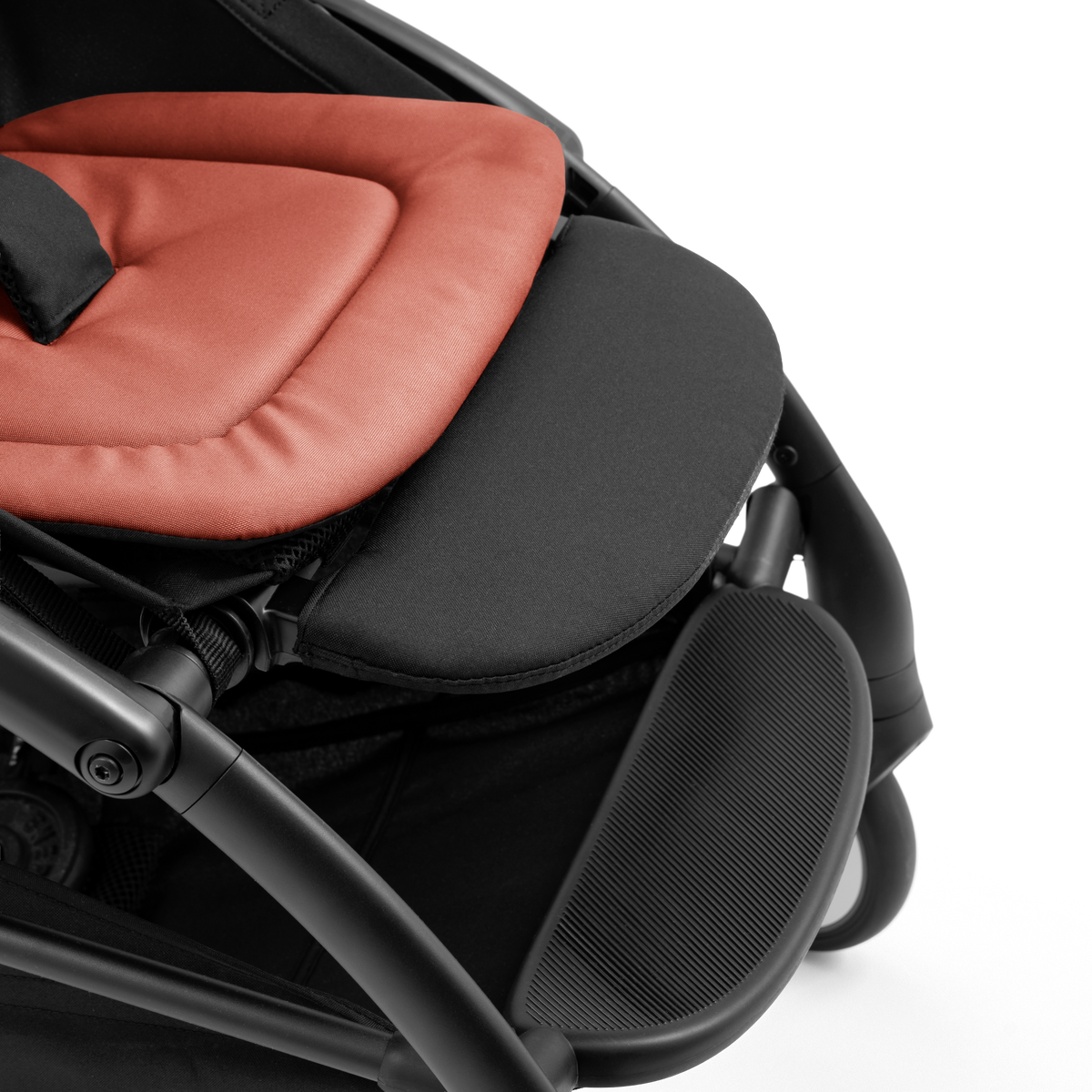 A compact yoyo 5 stroller with a rust-orange canopy and seat lining, a black frame, and black wheels, shown on a plain white background.