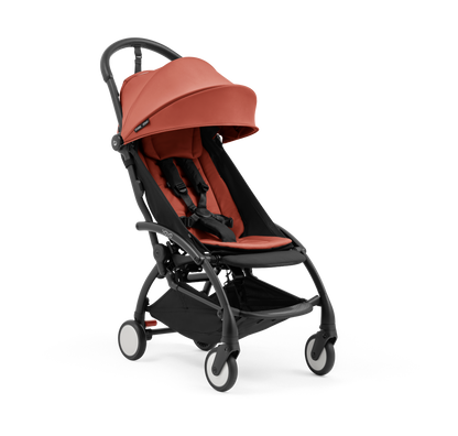 A compact yoyo 5 stroller with a rust-orange canopy and seat lining, a black frame, and black wheels, shown on a plain white background.