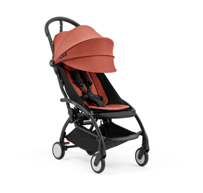 A compact yoyo 5 stroller with a rust-orange canopy and seat lining, a black frame, and black wheels, shown on a plain white background.