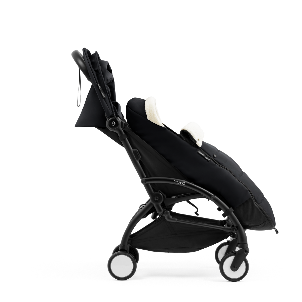 A stroller with a black colored padded footmuff, cream fleece lining, and a black frame, shown from the front on a white background.