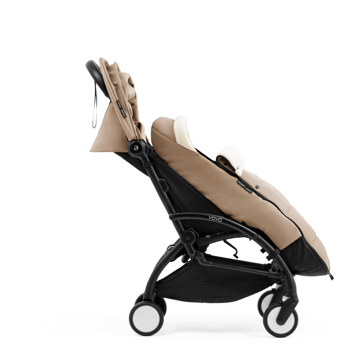 A stroller with a beige colored padded footmuff, cream fleece lining, and a black frame, shown from the front on a white background.