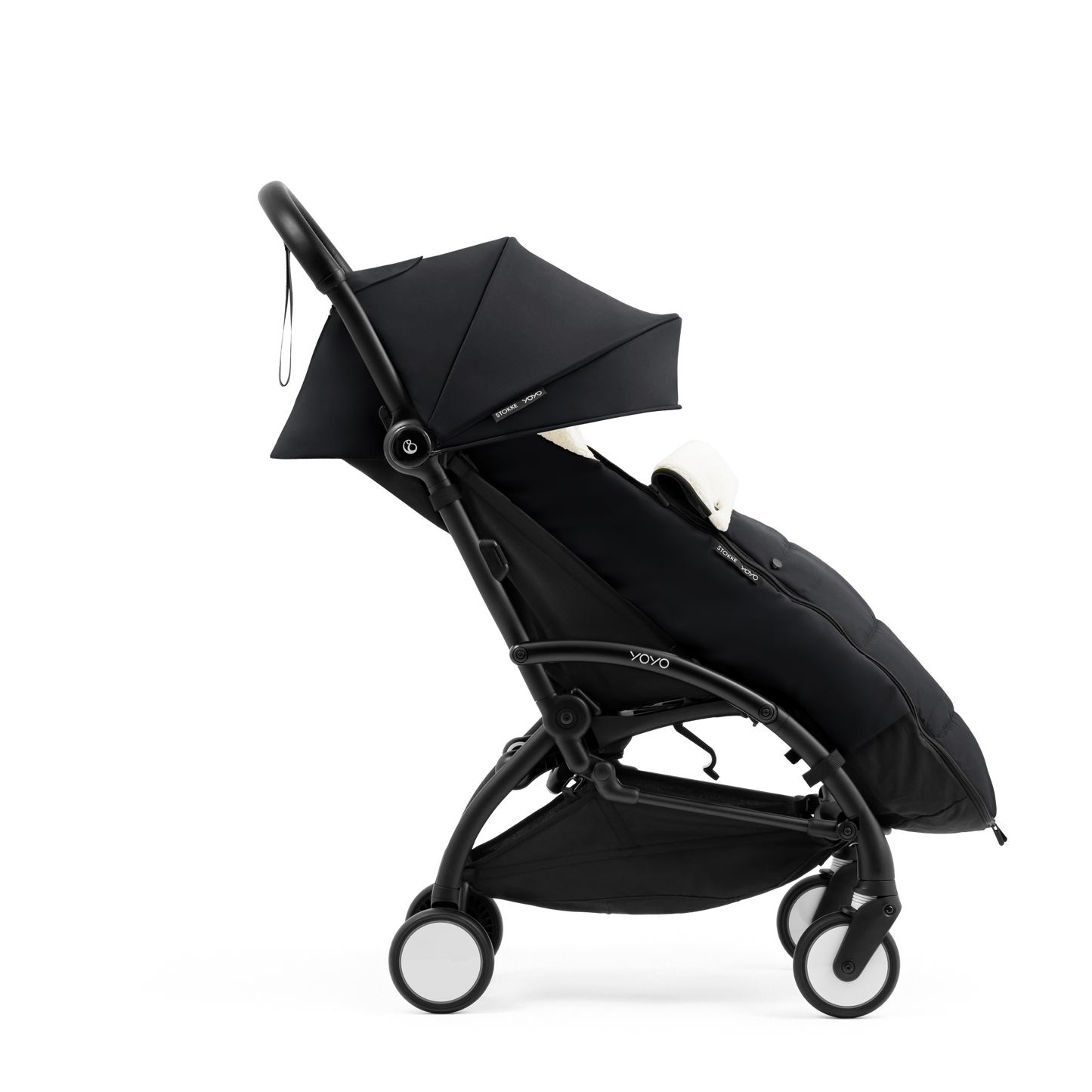 A stroller with a black colored padded footmuff, cream fleece lining, and a black frame, shown from the front on a white background.