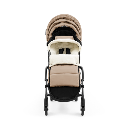 A stroller with a beige colored padded footmuff, cream fleece lining, and a black frame, shown from the front on a white background.