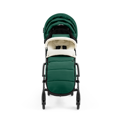 A stroller with a forest green colored padded footmuff, cream fleece lining, and a black frame, shown from the front on a white background.