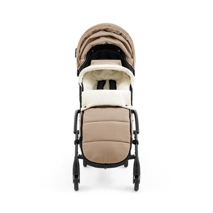 A stroller with a beige colored padded footmuff, cream fleece lining, and a black frame, shown from the front on a white background.