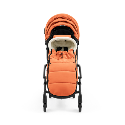 A stroller with a orange colored padded footmuff, cream fleece lining, and a black frame, shown from the front on a white background.
