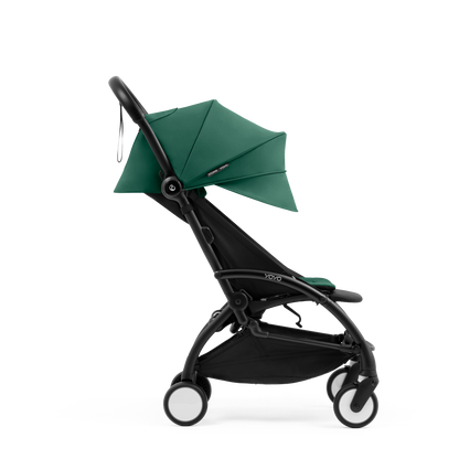 A compact yoyo 5 stroller with a green canopy and seat lining, a black frame, and black wheels, shown on a plain white background.