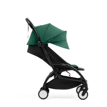 A compact yoyo 5 stroller with a green canopy and seat lining, a black frame, and black wheels, shown on a plain white background.