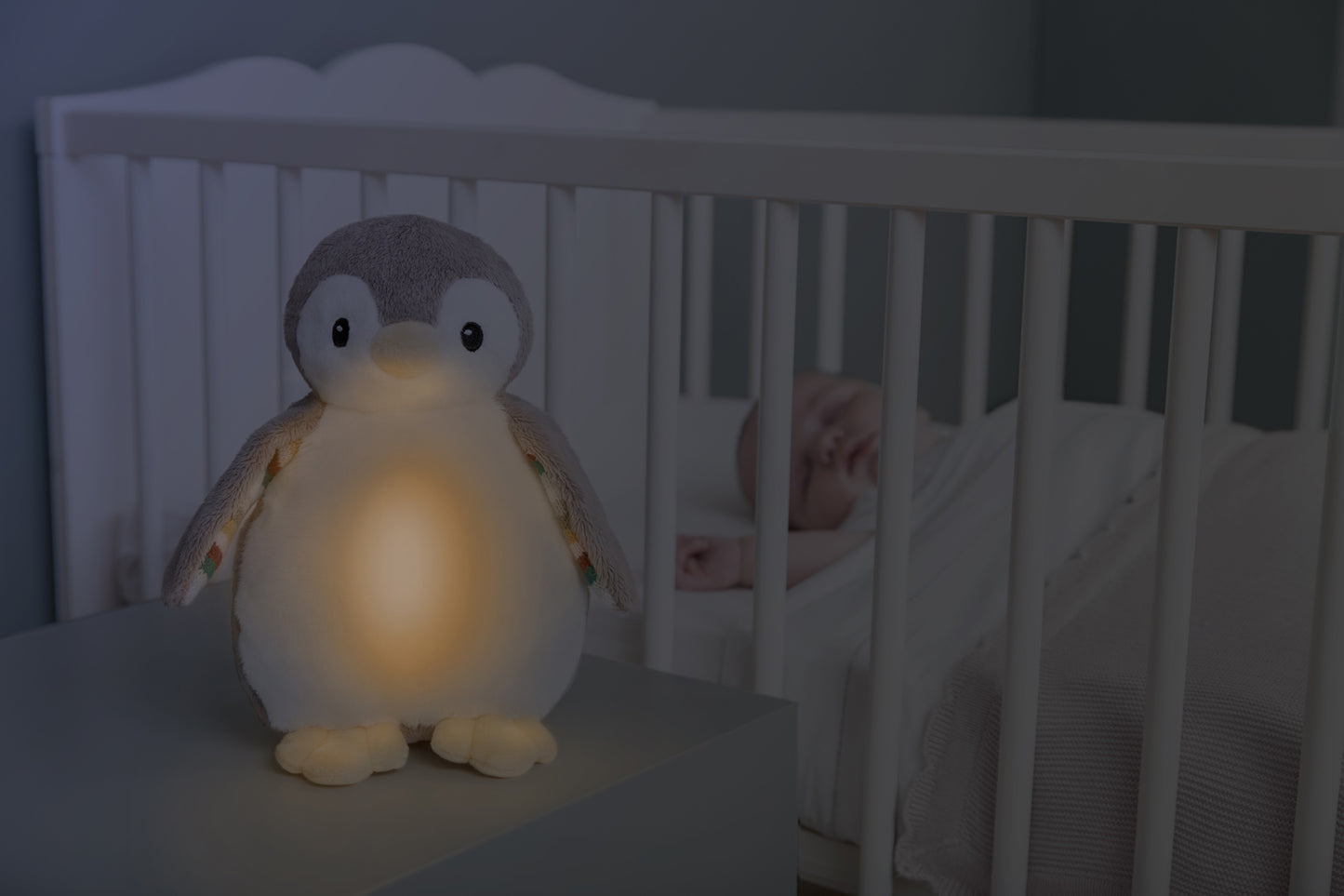 A beige and white bird with night light and soothing sounds, while baby sleeps in their cot.