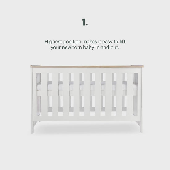 CuddleCo Burford cot bed in white with oak trim.